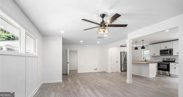 unfurnished living room with light wood finished floors, recessed lighting, visible vents, ceiling fan, and baseboards