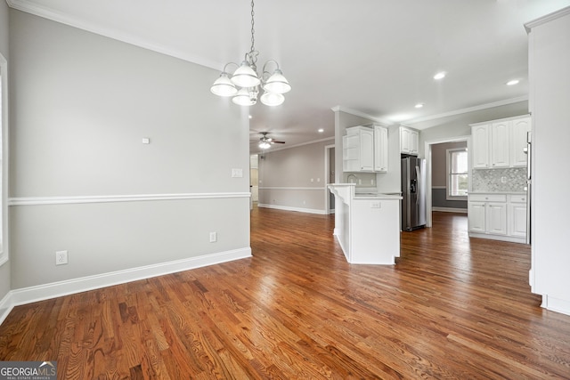 kitchen with tasteful backsplash, dark wood finished floors, stainless steel fridge with ice dispenser, open floor plan, and crown molding