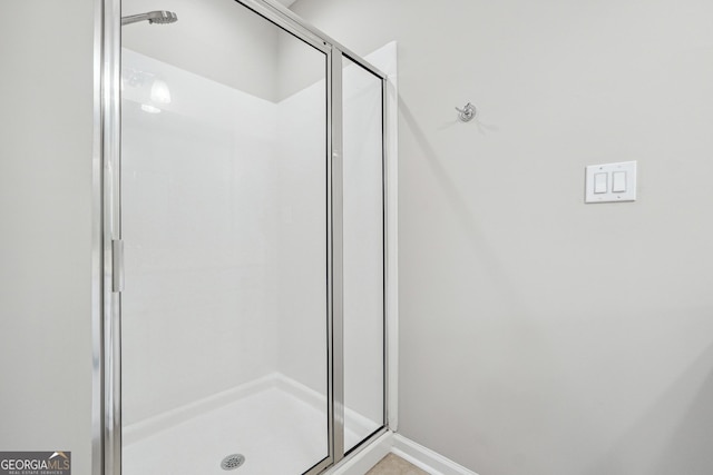 full bath with a stall shower and baseboards