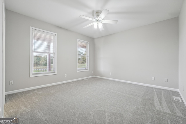 spare room with carpet, visible vents, ceiling fan, and baseboards