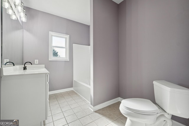 full bathroom with a tub to relax in, baseboards, toilet, tile patterned floors, and vanity