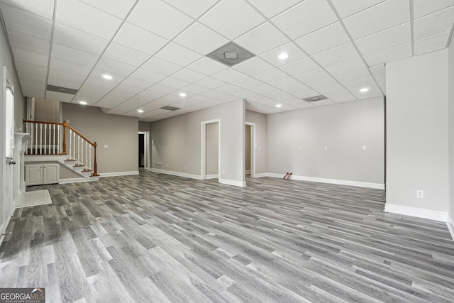 below grade area with baseboards, stairway, wood finished floors, and recessed lighting