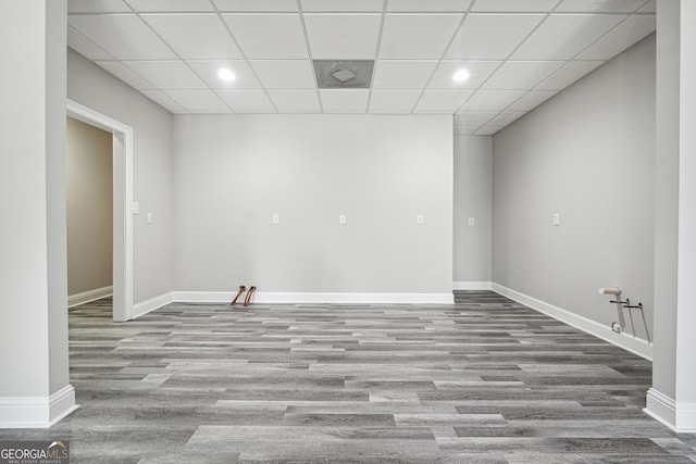 below grade area featuring baseboards, a drop ceiling, wood finished floors, and recessed lighting