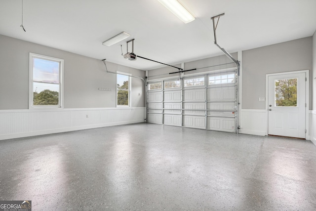 garage with a garage door opener and a wainscoted wall