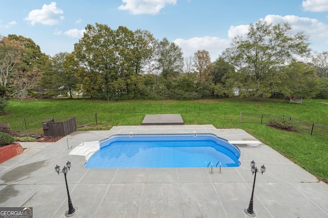 view of swimming pool with a patio, a lawn, and fence