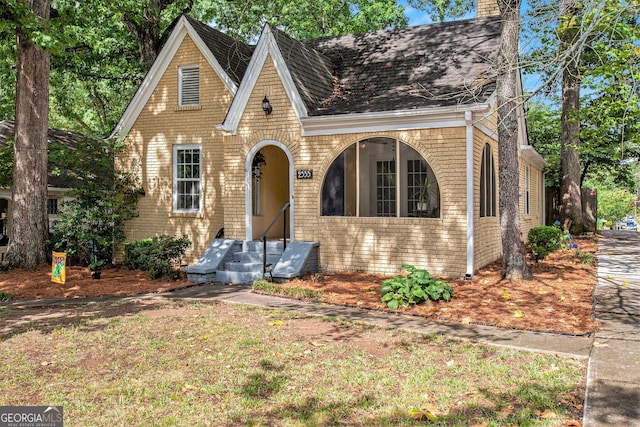 tudor home with a chimney and brick siding