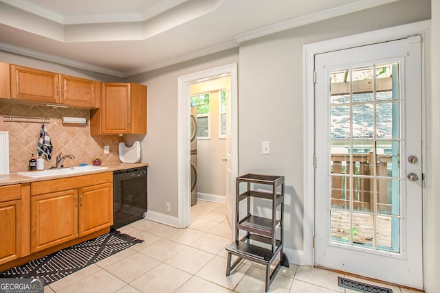 kitchen featuring black dishwasher, ornamental molding, a tray ceiling, light countertops, and a sink