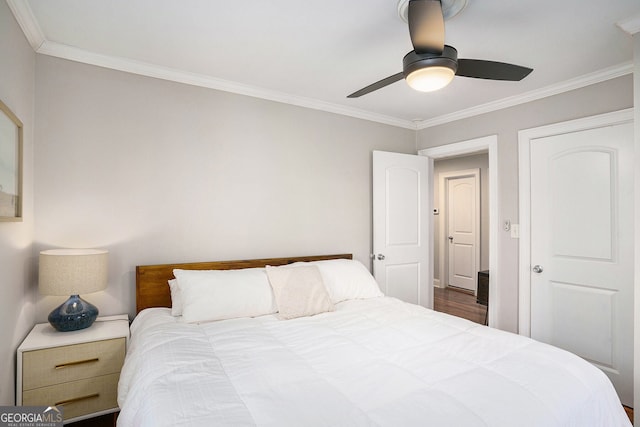 bedroom with ceiling fan, ornamental molding, and wood finished floors