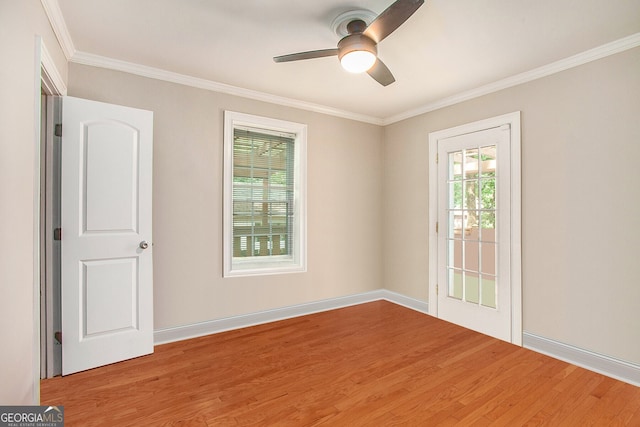 unfurnished room featuring ceiling fan, a healthy amount of sunlight, crown molding, and wood finished floors