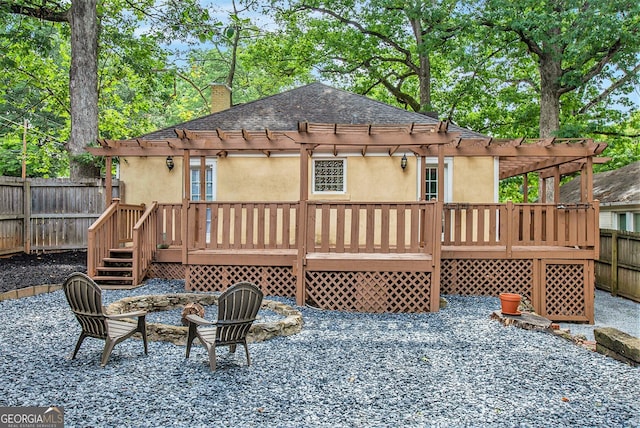 back of house featuring a pergola, a fenced backyard, a wooden deck, and stucco siding
