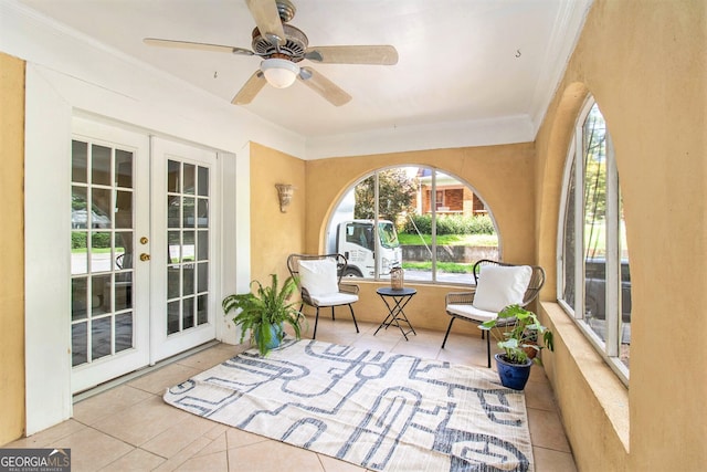 sunroom featuring a ceiling fan and french doors