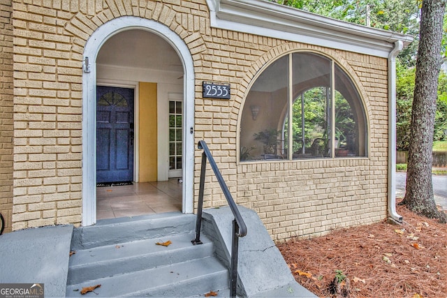 doorway to property featuring brick siding