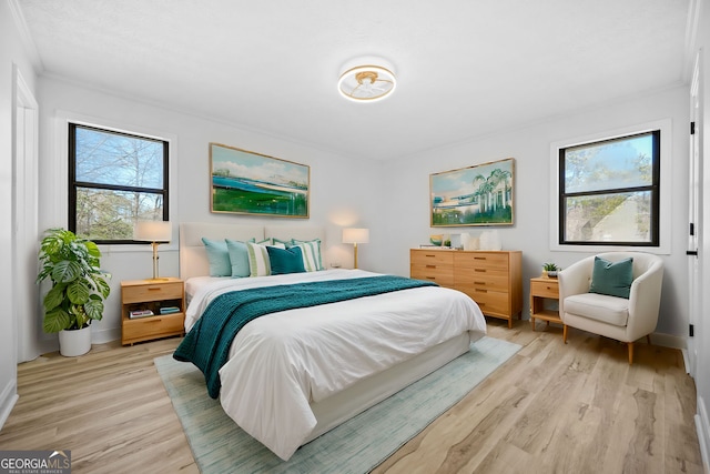 bedroom with light wood finished floors, baseboards, multiple windows, and ornamental molding