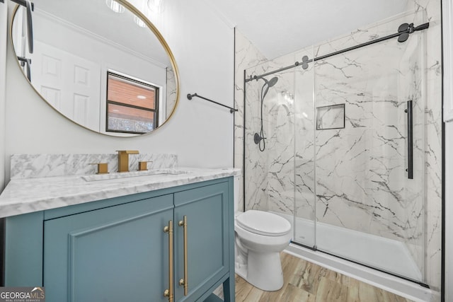 bathroom featuring vanity, wood finished floors, a marble finish shower, and toilet