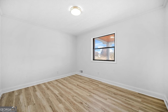 spare room featuring visible vents, baseboards, and wood finished floors