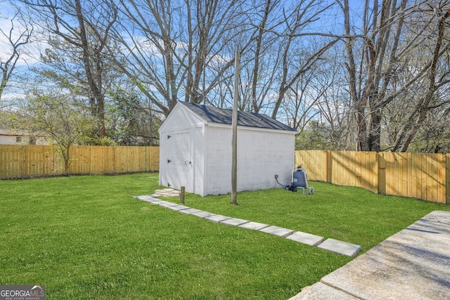 view of yard featuring a storage shed, a fenced backyard, and an outdoor structure