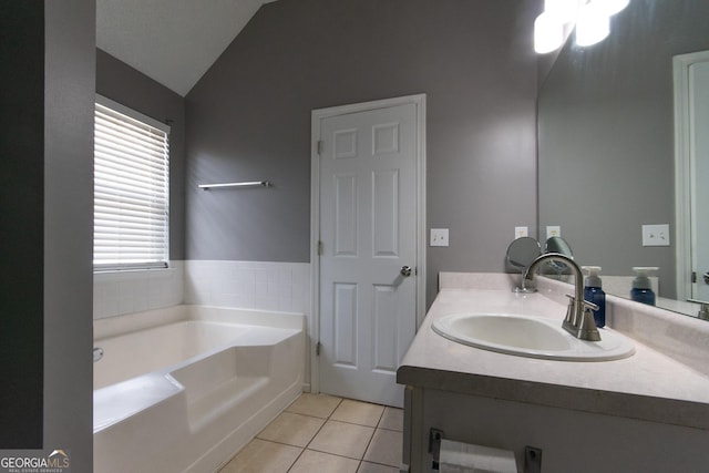 full bath featuring a garden tub, vaulted ceiling, tile patterned flooring, and vanity