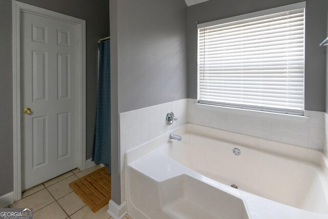 bathroom with tile patterned flooring and a bath