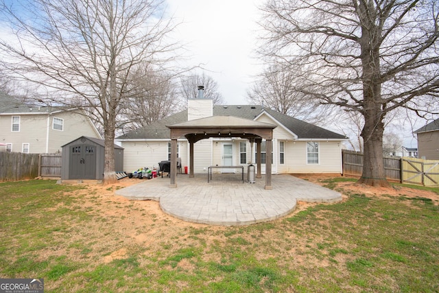 back of house with an outbuilding, a patio, a gazebo, a shed, and a chimney