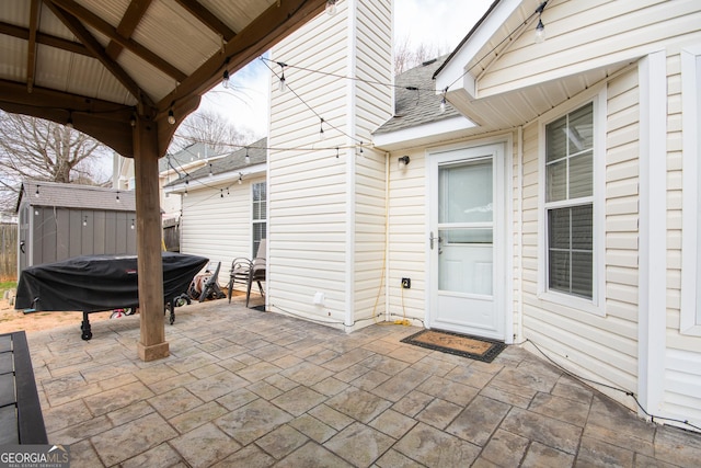 view of patio / terrace with a grill, a storage unit, and an outdoor structure