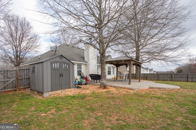 view of yard featuring a patio, a storage unit, a gazebo, a fenced backyard, and an outdoor structure