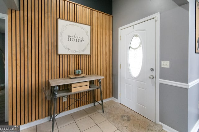 foyer entrance with light tile patterned flooring and baseboards