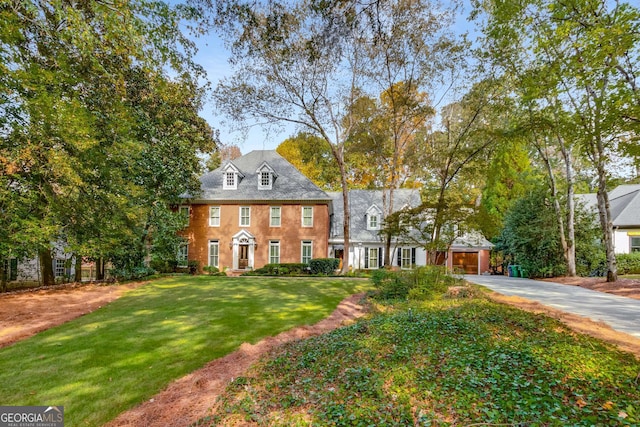 colonial home featuring a front yard and concrete driveway