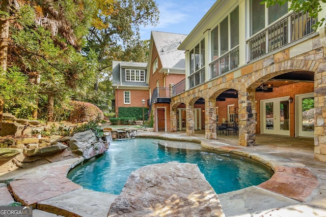 outdoor pool with a patio area, a jacuzzi, and french doors