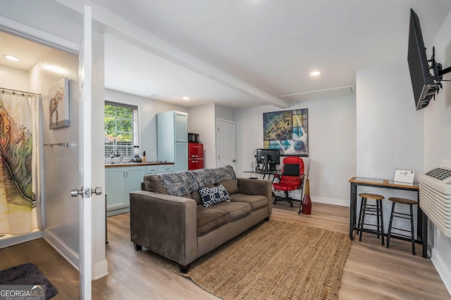 living room with recessed lighting, light wood-type flooring, baseboards, and beamed ceiling