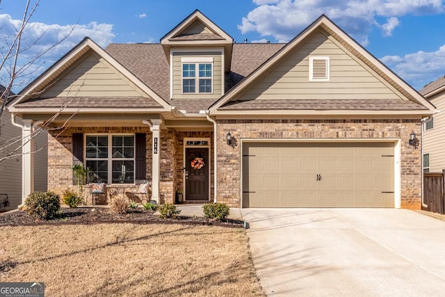 view of front facade with a porch, brick siding, driveway, and an attached garage