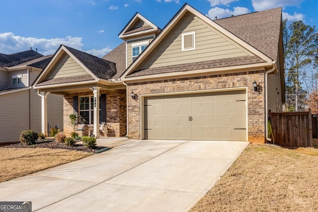 view of front of property featuring an attached garage, driveway, fence, and brick siding