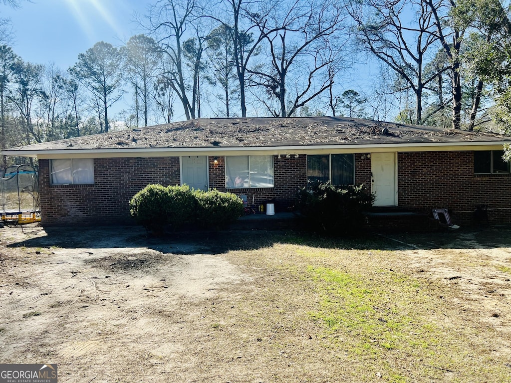 ranch-style house featuring brick siding