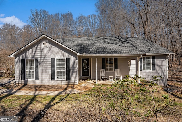 ranch-style home featuring covered porch and roof with shingles