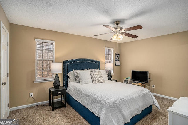 carpeted bedroom with multiple windows, a textured ceiling, and baseboards