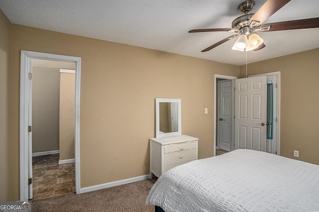 carpeted bedroom featuring a ceiling fan, baseboards, and a textured ceiling