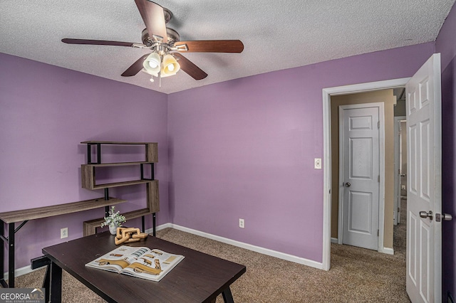 office area with a textured ceiling, ceiling fan, carpet flooring, and baseboards