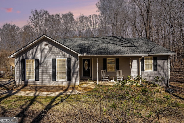 single story home featuring covered porch and a shingled roof