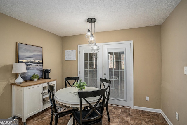 dining room with stone finish flooring, baseboards, and a textured ceiling