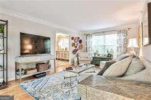 living area with ornamental molding and wood finished floors