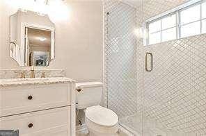 full bath with toilet, an enclosed shower, and vanity