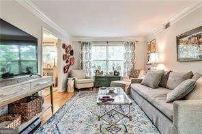 living room with crown molding and wood finished floors