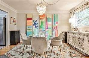 dining area featuring ornamental molding and a notable chandelier