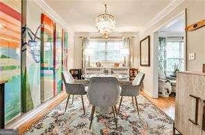 dining area featuring a notable chandelier, crown molding, and wood finished floors