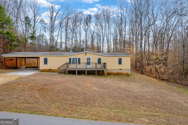 manufactured / mobile home featuring an attached carport, crawl space, driveway, and a wooden deck