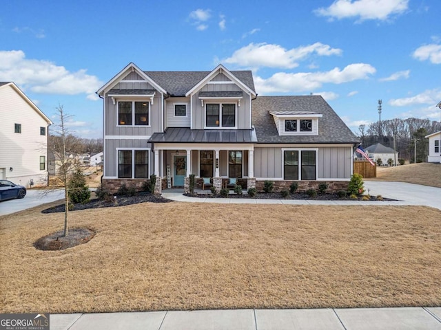 craftsman inspired home featuring a shingled roof, a standing seam roof, a porch, board and batten siding, and a front yard