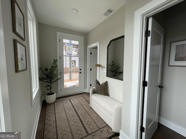 doorway to outside featuring wood finished floors, visible vents, and baseboards