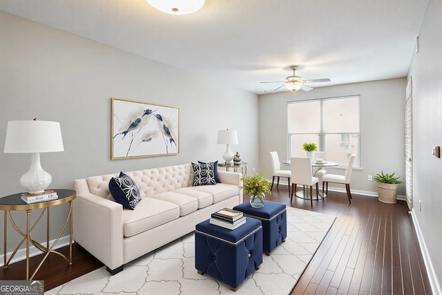 living room featuring ceiling fan, baseboards, and wood finished floors