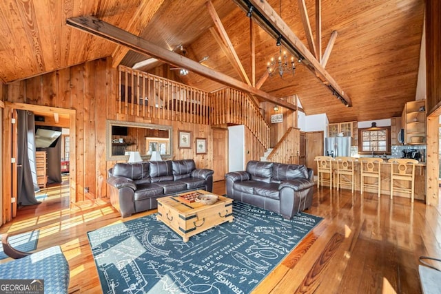 living room featuring wooden walls, wood ceiling, stairway, hardwood / wood-style floors, and rail lighting