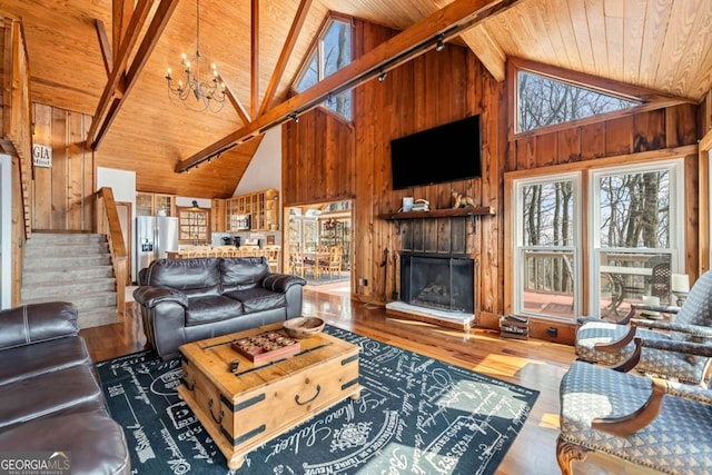 living room featuring wood ceiling, wood walls, stairway, and wood finished floors