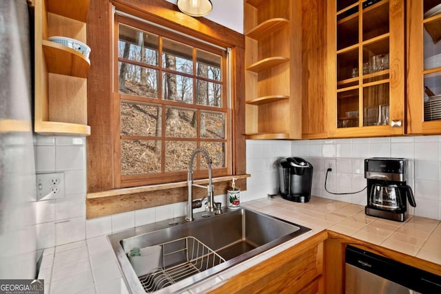 kitchen featuring dishwasher, open shelves, a sink, and tile counters